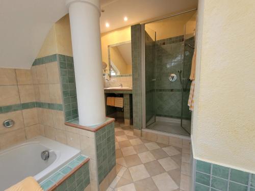 a bathroom with a bath tub and a shower at Appartementhaus Steiger in Bad Füssing