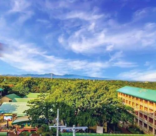 a view of a city with trees and a building at Happy Stays A - Sunset View at SMDC Hope Residences in Trece Martires