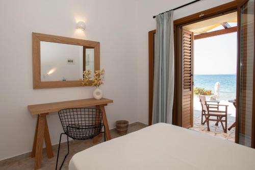 Dormitorio con cama, espejo y océano en Asterias Studios Finikounda, en Finikounta