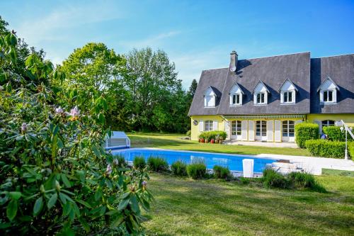 a house with a swimming pool in front of it at La Fontaine Dort in Tessy-sur-Vire