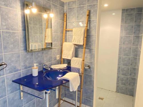 a bathroom with a blue sink and a shower at Les Mariniers Chambres d'Hôtes à la campagne avec aire de jeux - Spa nordique en option in Mareuil-sur-Cher