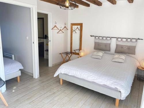 a bedroom with a white bed with two pillows on it at Les Mariniers Chambres d'Hôtes à la campagne avec aire de jeux - Spa nordique en option in Mareuil-sur-Cher