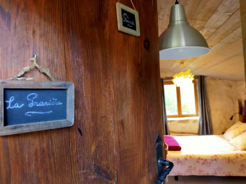 a room with a sign on a wooden wall at Gites de Fouard "La Pranièra" in Malaurier