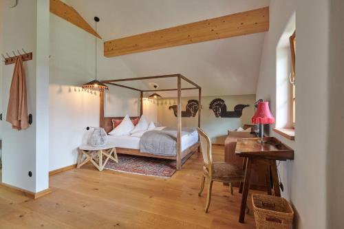 um quarto com uma cama de dossel e uma secretária em Farmhouse 1604 em Übersee