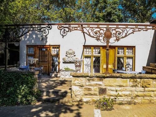 a house with an ornate gate and a stone wall at The Green Acorn Guest House in Ficksburg