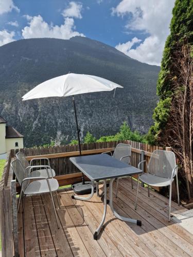 a table and chairs on a deck with an umbrella at Haus Knoll in Imsterberg