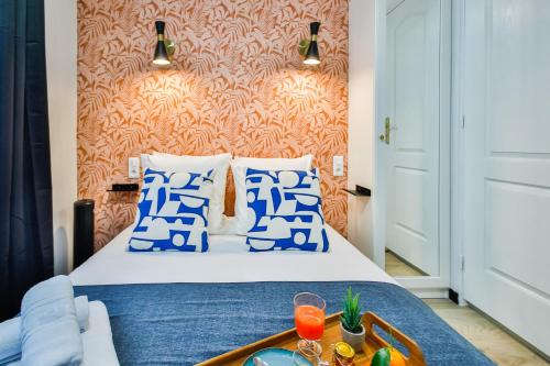 - une chambre avec un lit doté d'oreillers bleus et blancs dans l'établissement Apartments WS Louvre - Saint-Roch, à Paris
