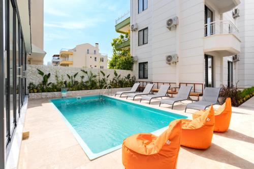a swimming pool with orange chairs and a swimming poolvisorvisor at ECHINUS HOTELS in Lara