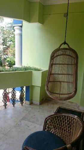 a room with a table and chairs and a swing at Anitha's Garden Stay in Kovalam
