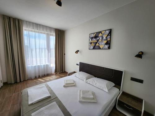 a bedroom with a large white bed and a window at Golden Sands Apartments Zlatna Kotva in Golden Sands