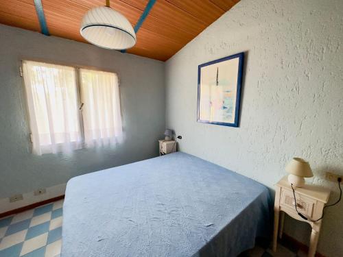 a bedroom with a blue bed and a window at Bilocale a due passi dalla piazza di Rena Majore in Rena Majore