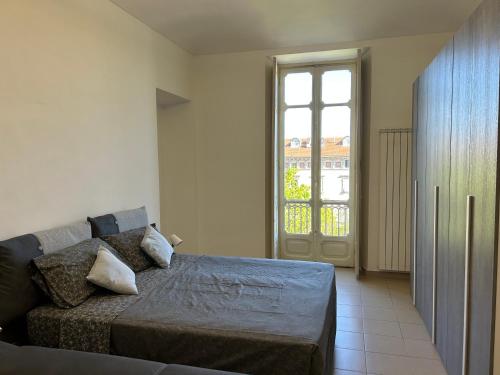 ein Schlafzimmer mit einem Bett und einem großen Fenster in der Unterkunft Typical one bedroom apartment in Turin center in Turin