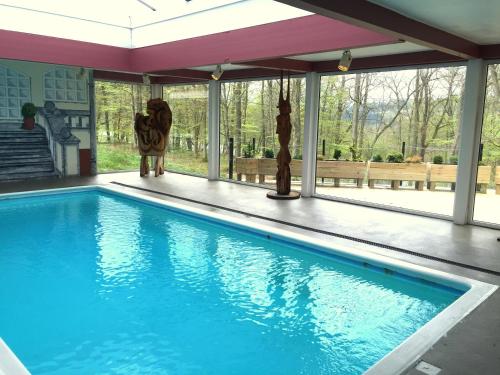 a swimming pool in a house with a large window at Rold Storkro in Skorping