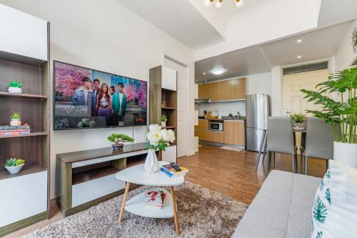 uma sala de estar com uma mesa e uma cozinha em Amani 237, 3 Minutes from the Airport, Free Netflix, Free Wifi em Pusok