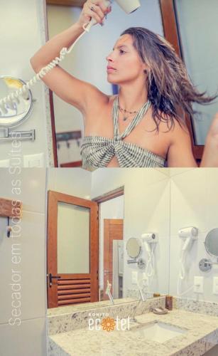 a woman brushing her hair in front of a mirror at Bonito Ecotel in Bonito