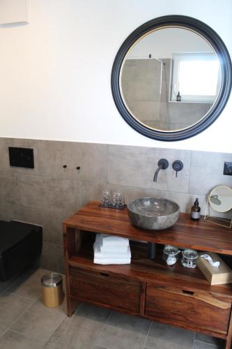 a bathroom with a sink and a mirror at Ewitsch 13 - Hotel Garni in Berghausen