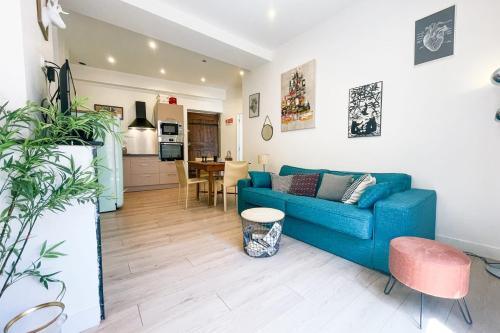 un salon avec un canapé bleu et une cuisine dans l'établissement #B1 Chez Giuseppe City center pedestrian streets, à Grenoble