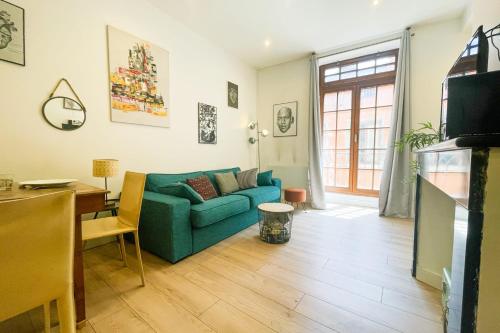 un salon avec un canapé bleu et une table dans l'établissement #B1 Chez Giuseppe City center pedestrian streets, à Grenoble