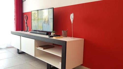 d'un bureau avec une télévision sur un mur rouge. dans l'établissement Cap d'Agde Port Nature, au Cap d'Agde