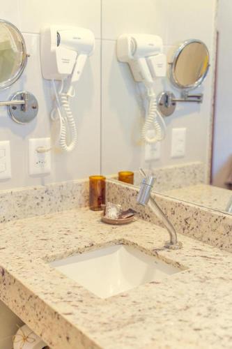 a bathroom counter with a sink and phones on the wall at Bonito Ecotel in Bonito