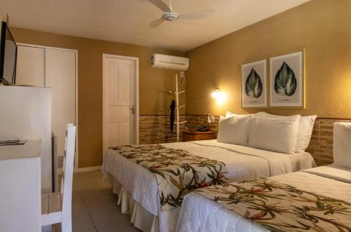 a hotel room with two beds and a refrigerator at Hotel Fazenda Vilarejo All Inclusive in Conservatória