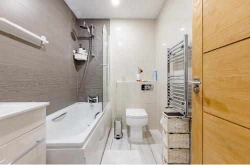 a bathroom with a tub and a toilet and a sink at Double Room Charlotte in London