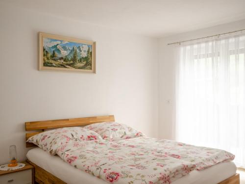 a bed in a bedroom with a picture on the wall at Gästehaus Tannenberg in Bayerisch Gmain