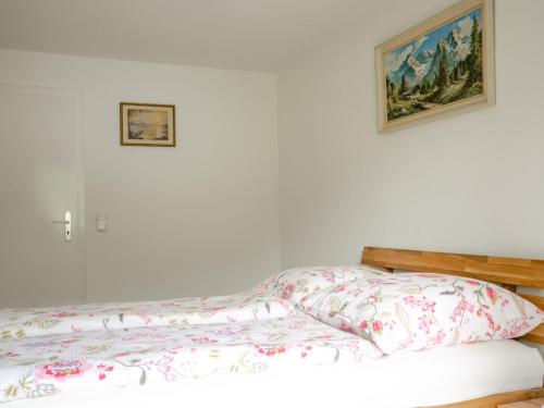 a bed with a comforter and a picture on the wall at Gästehaus Tannenberg in Bayerisch Gmain