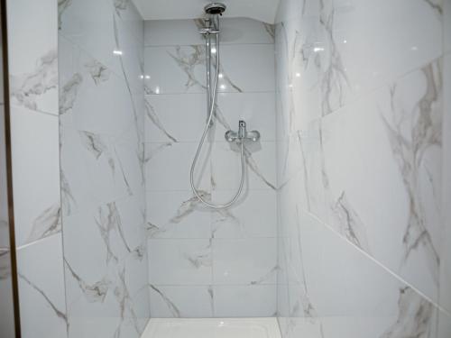 ein Bad mit einer Dusche und weißen Marmorwänden in der Unterkunft Gästehaus Tannenberg in Bayerisch Gmain