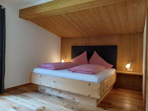 a bed in a room with a wooden ceiling at Haus Petra in Bach