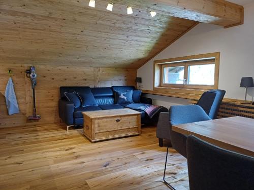 a living room with a blue couch and a table at Haus Petra in Bach