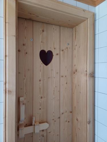 a wooden shower with a heart on the wall at Haus Petra in Bach