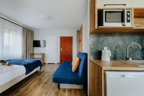 a hotel room with a bed and a kitchen at AQUA in Karwia