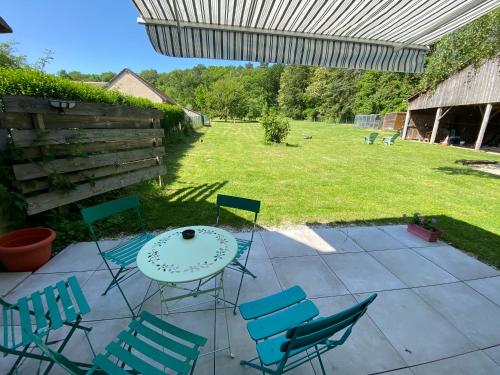 a patio with chairs and a table in a yard at Les Mariniers Chambres d'Hôtes à la campagne avec aire de jeux - Spa nordique en option in Mareuil-sur-Cher