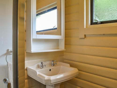 a bathroom with a sink and a window at Rockhall - Souter Johnnies Cabin in Collin