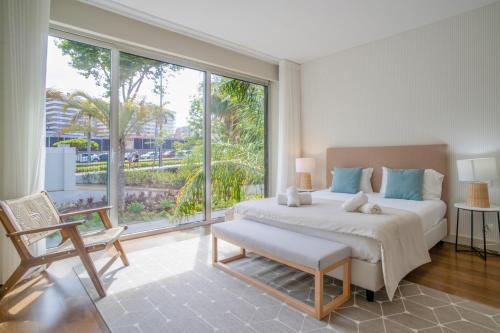een slaapkamer met een groot bed en een groot raam bij Madeira Residence Apt. 80 in Funchal