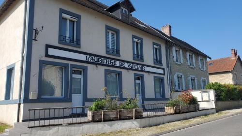 un bâtiment avec un panneau sur son côté dans l'établissement L'Auberge de Vauclair, à Bouconville-Vauclair