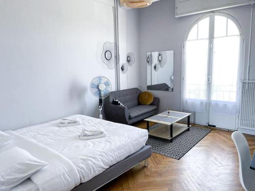 ein Schlafzimmer mit einem Bett, einem Stuhl und einem Sofa in der Unterkunft Fabre / Appartement central proche de la gare in Antibes