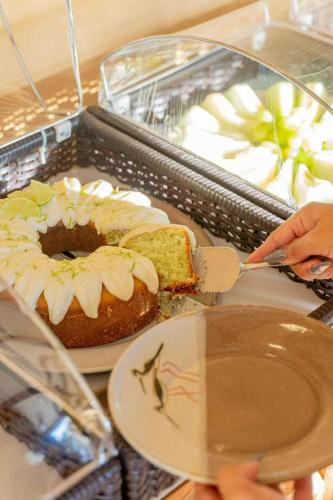 a person cutting a piece of cake with a knife at Bonito Ecotel in Bonito