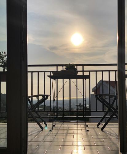 a table and chairs on a balcony with the sun in the sky at Cerchia Apartments in Corbara