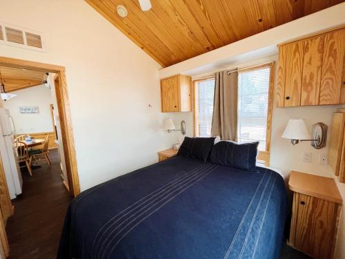 a bedroom with a blue bed in a room at Sally's Cabin is a quaint two bedroom tiny home in Woodland Park