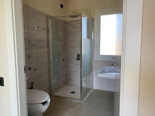 a bathroom with a shower and a toilet and a sink at Is Arenas Biancas Agriturismo in Teulada