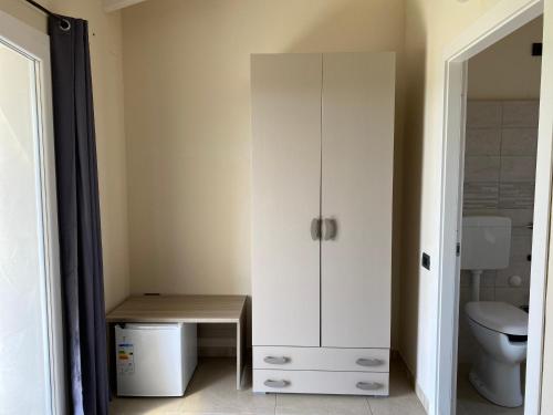 a white cabinet in a bathroom with a toilet at Is Arenas Biancas Agriturismo in Teulada
