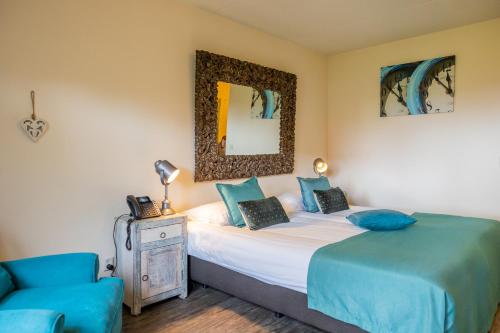 a bedroom with a bed and a chair and a mirror at Hotel De Walvisvaarder in Lies