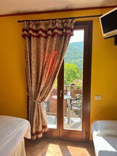 a bedroom with a sliding glass door with a view at La Griglia Hotel in Argegno