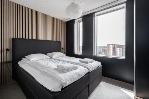 a bedroom with a large bed with a black headboard at 2ndhomes Tampere "Kansi" Apartment - 15th Floor Apt with Jacuzzi and 60m2 Terrace in Tampere