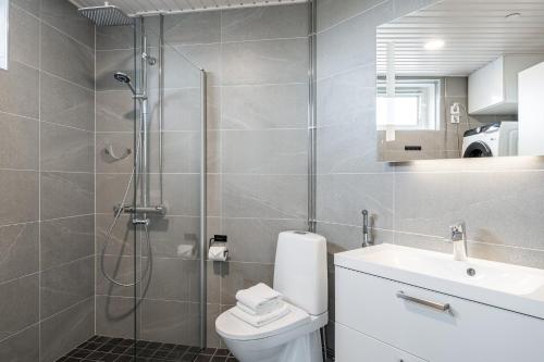 a bathroom with a shower and a toilet and a sink at 2ndhomes Tampere "Kansi" Apartment - 15th Floor Apt with Jacuzzi and 60m2 Terrace in Tampere