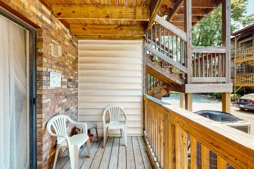 a porch with two chairs and a wooden staircase at Sandalwoods 101A in Ocean City