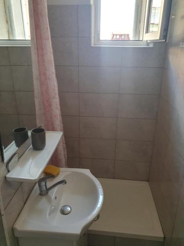 a small bathroom with a sink and a window at Sweet in Sibiu