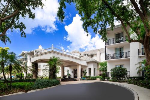 an exterior view of a large white building at The Capri Inn in Naples